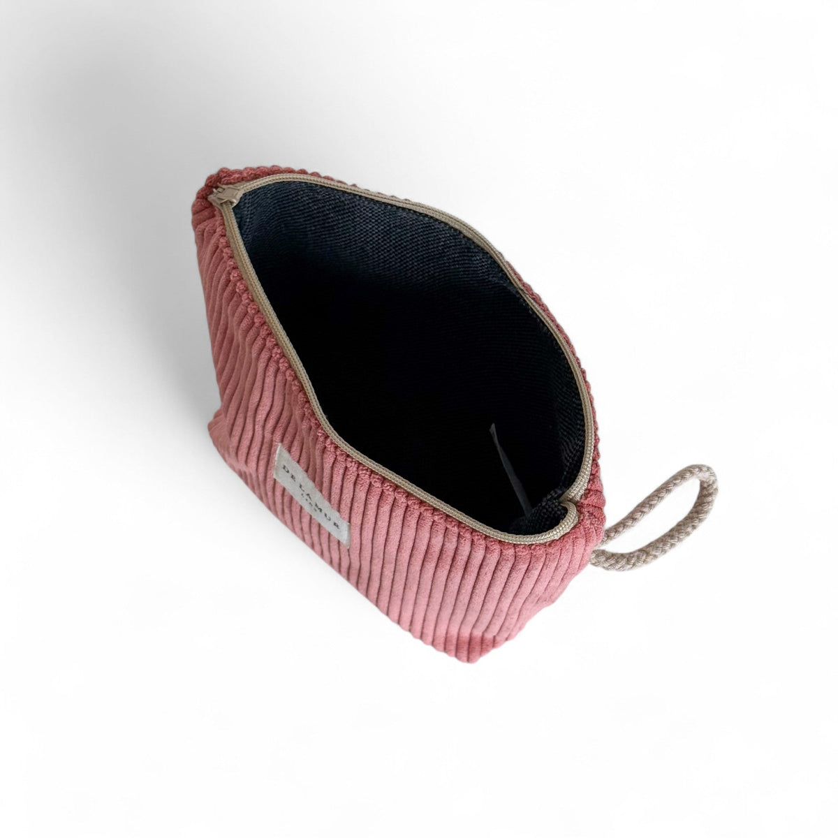Open pink Coral makeup bag showing the dark lined interior