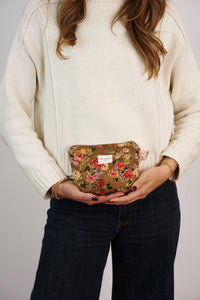Model holding the floral jacquard DE LA MUR makeup bag, lifestyle shot