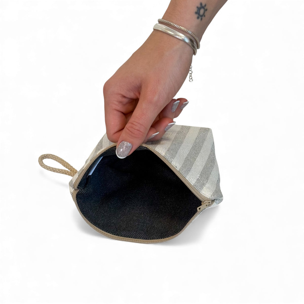 Open DE LA MUR Lugris makeup bag showing the dark lined interior and zip