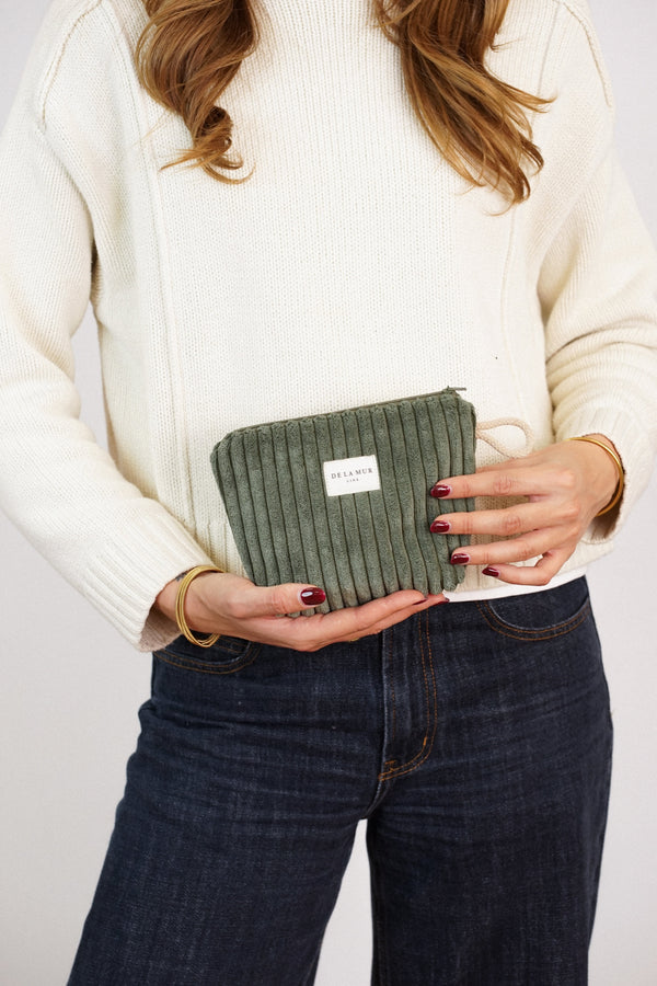 Model holding DE LA MUR olive green corduroy small makeup bag (Musgo)