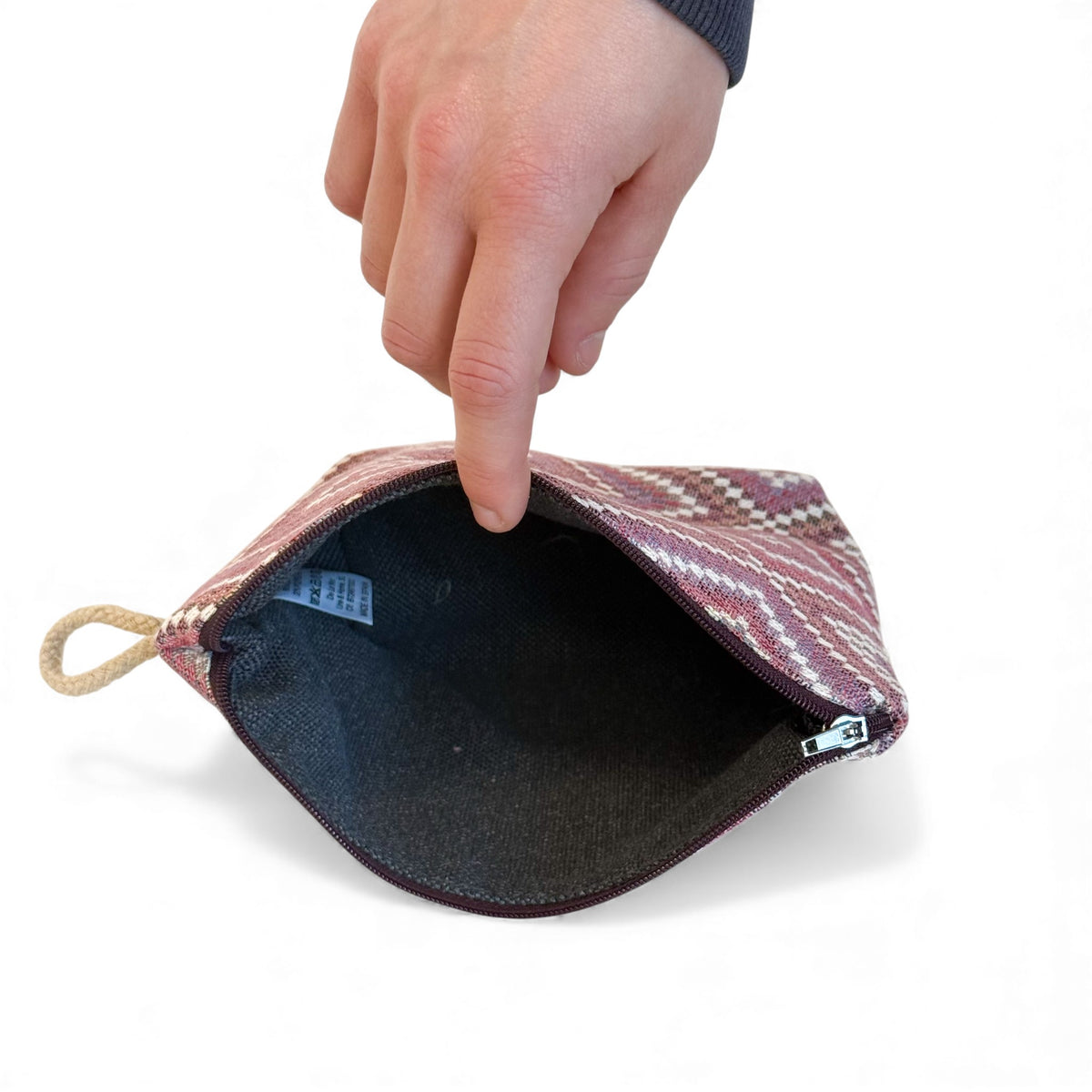 Open DE LA MUR Nana makeup bag showing the dark lined interior and zip