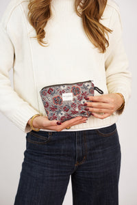 Woman holding the DE LA MUR Nira floral jacquard small makeup bag