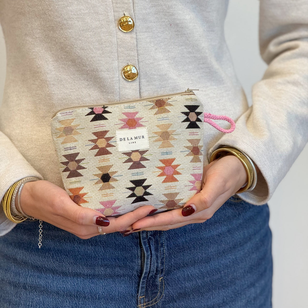 Model holding the DE LA MUR Royal jacquard makeup bag in both hands