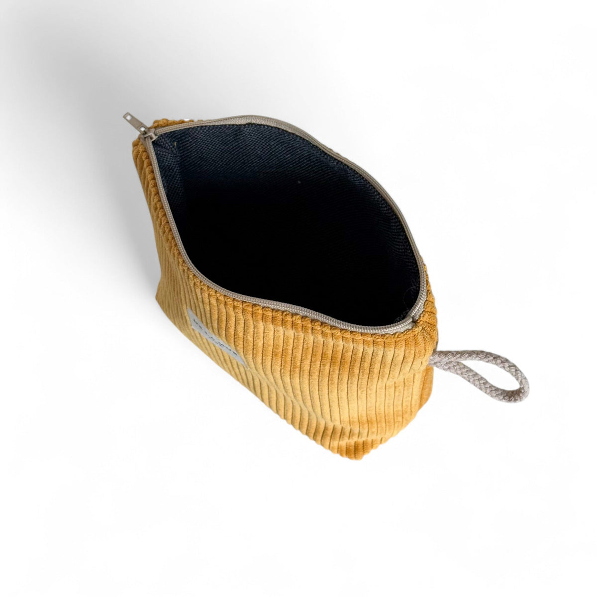 Open DE LA MUR Taz mustard corduroy makeup bag showing black interior lining