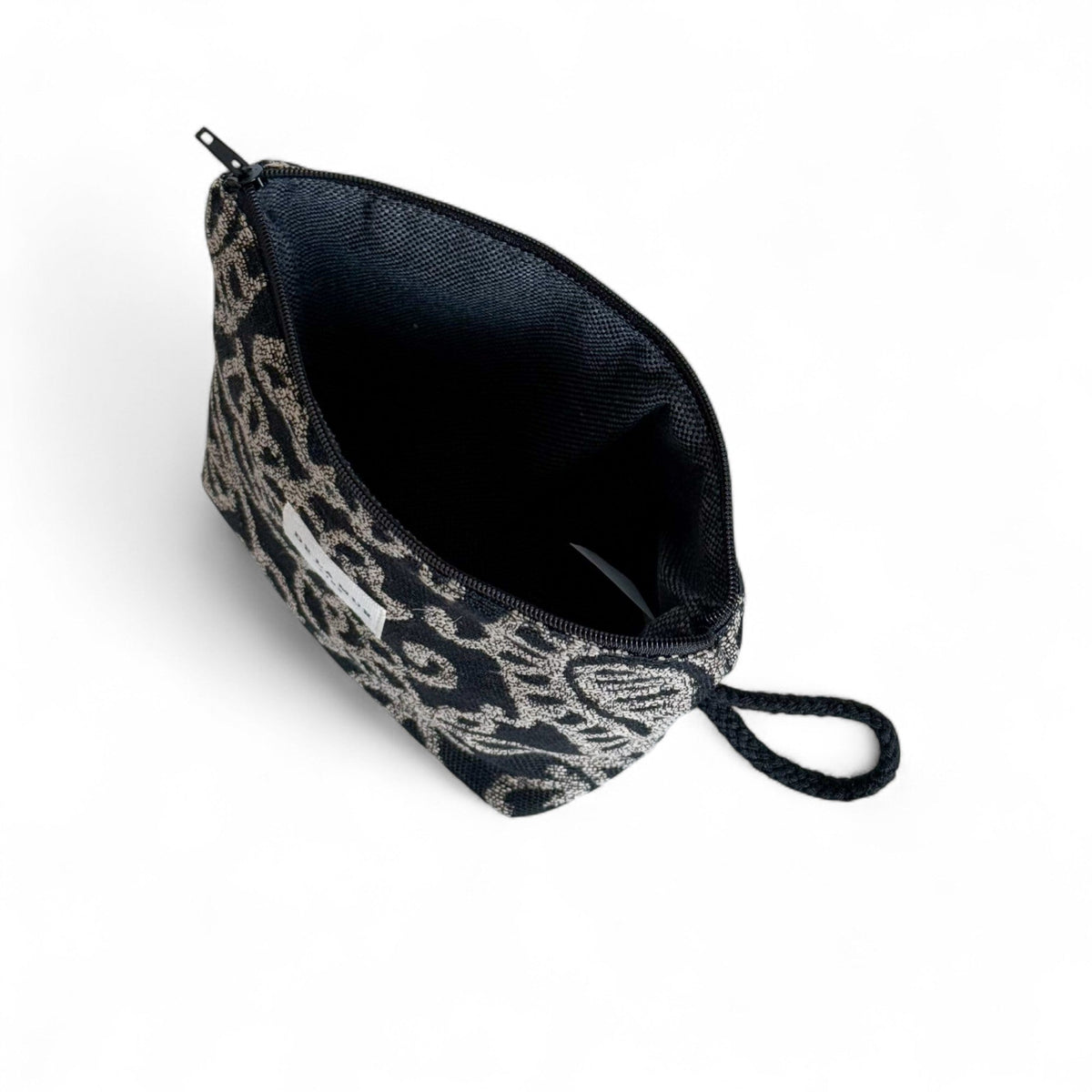 Open DE LA MUR Teide makeup bag showing the dark lined interior