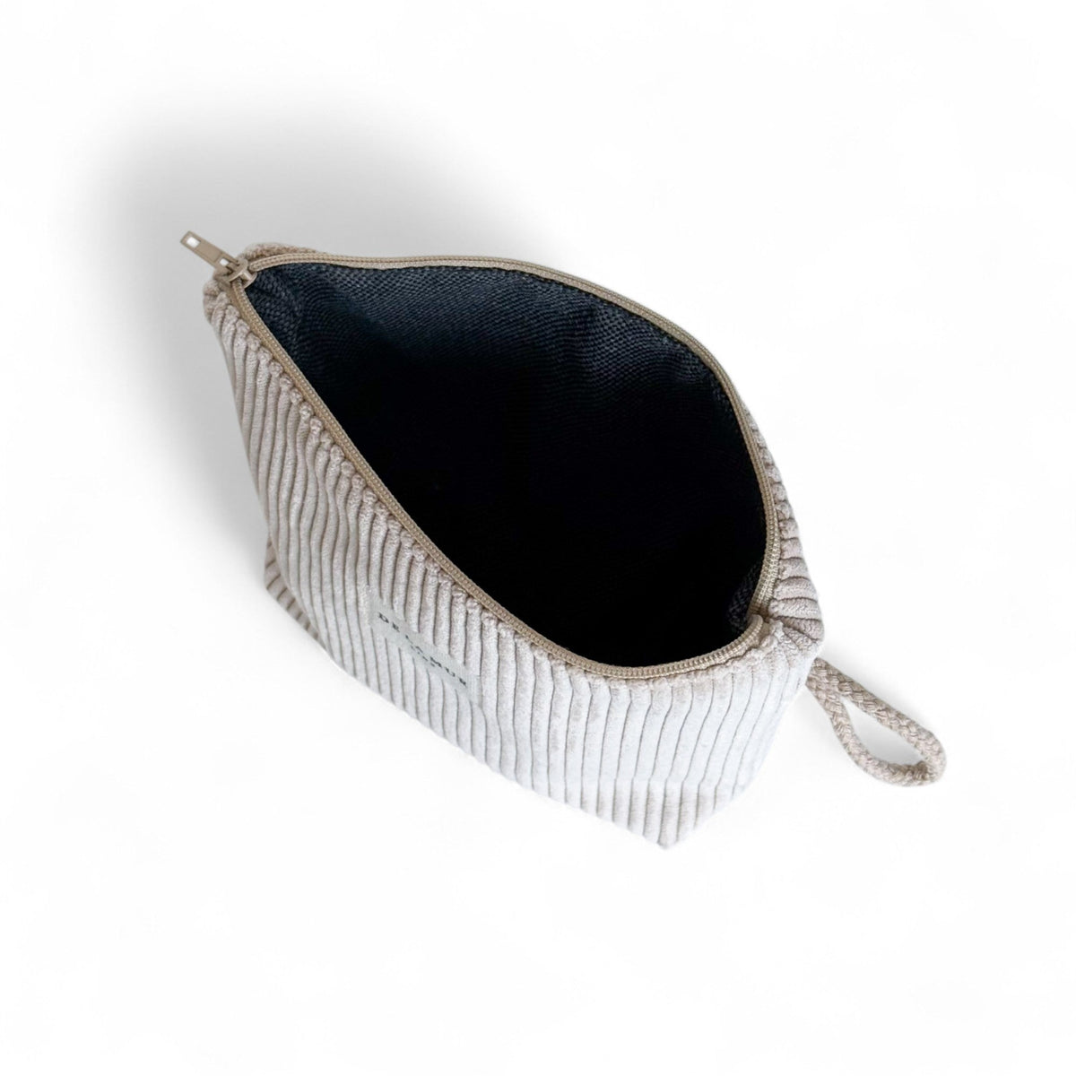 Open beige Tofe makeup bag showing the dark lined interior