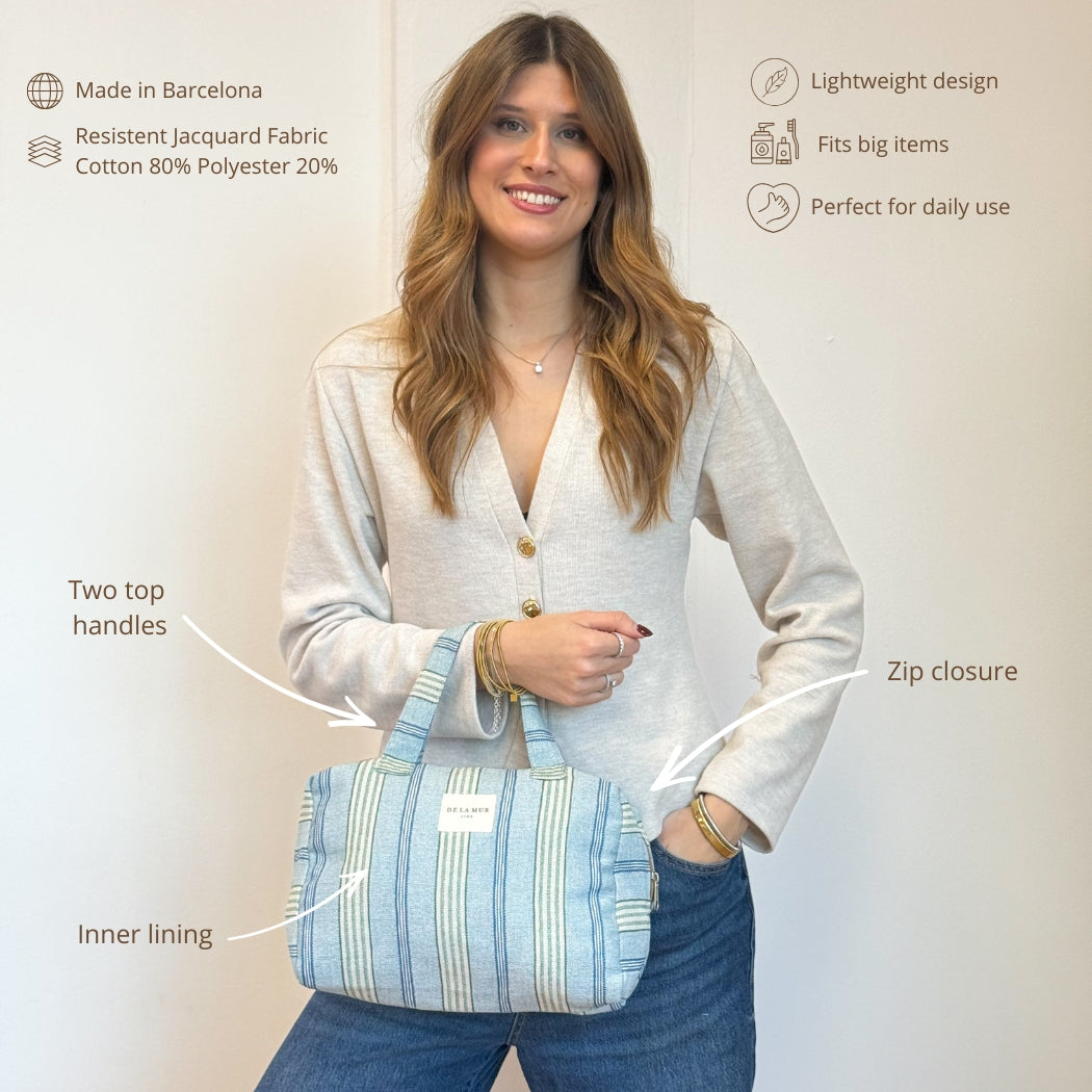 Model holding the DE LA MUR Cata striped handled bag with feature callouts