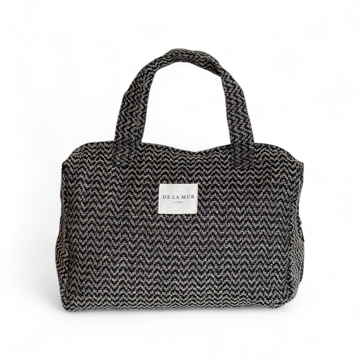 DE LA MUR Dana zigzag jacquard XL makeup bag in black and beige chevron, front view with handles