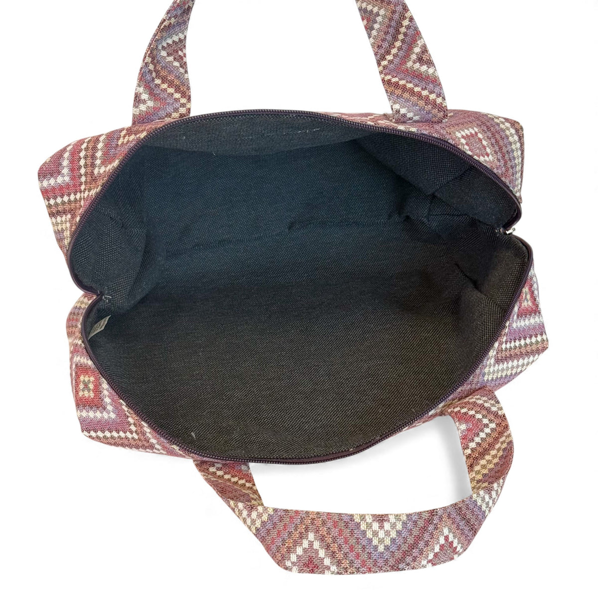 Open DE LA MUR geometric makeup bag showing the dark lined interior