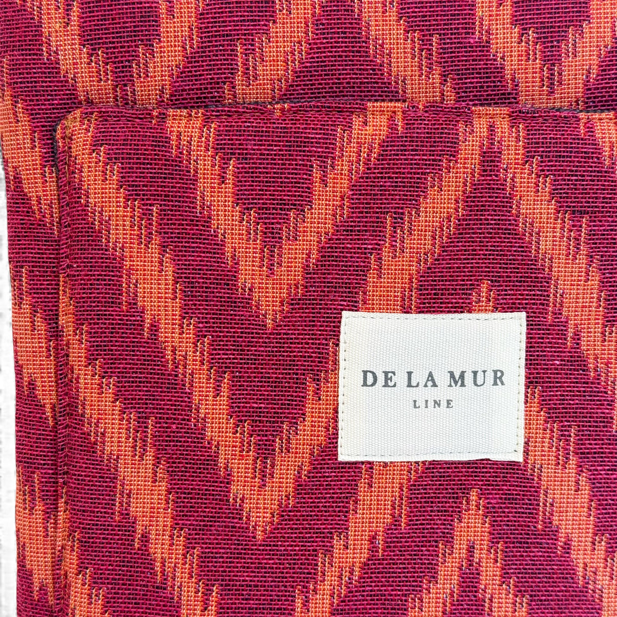 Detail of the DE LA MUR Line label on the zigzag jacquard laptop bag fabric