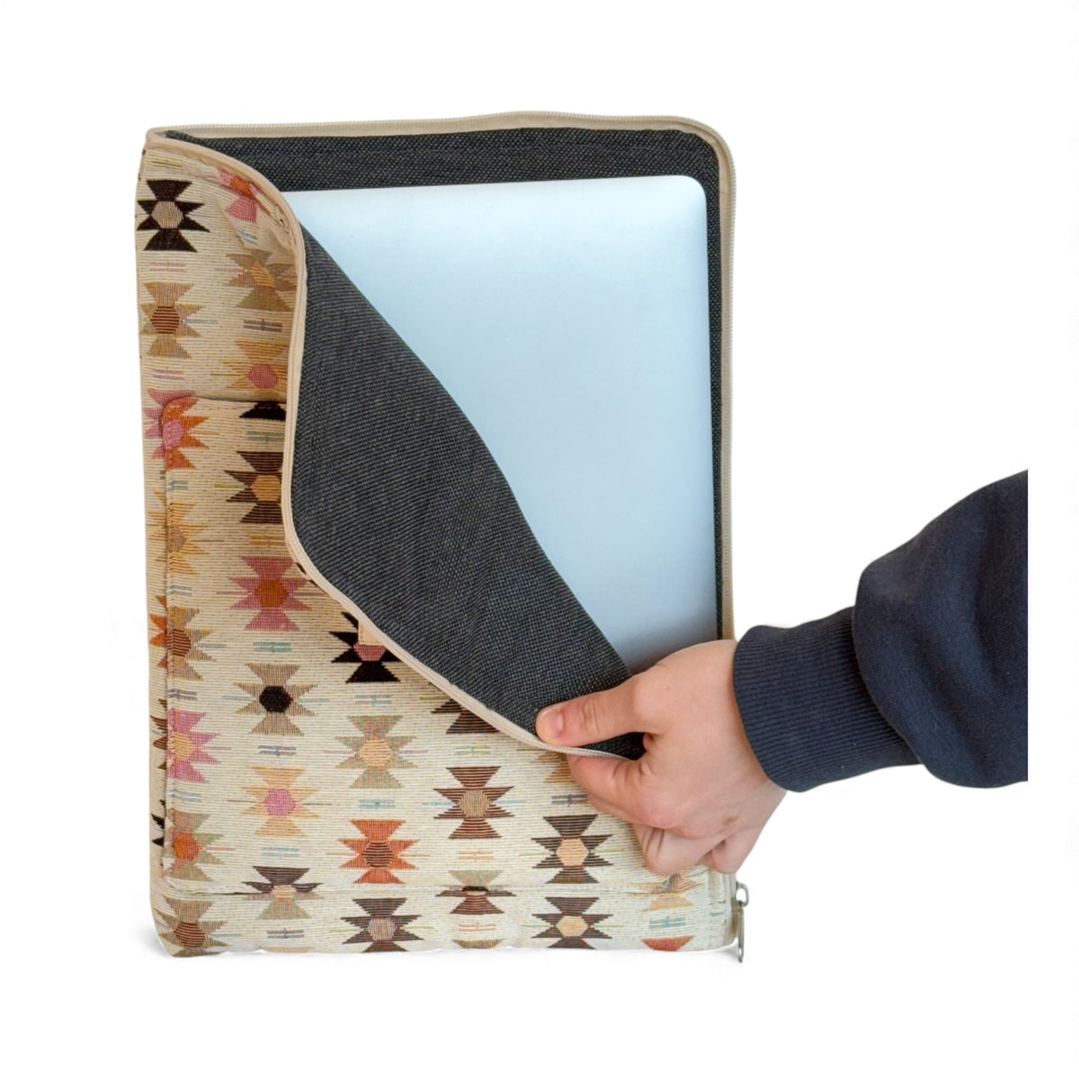 Hand sliding a laptop out of the open DE LA MUR Royal padded laptop sleeve