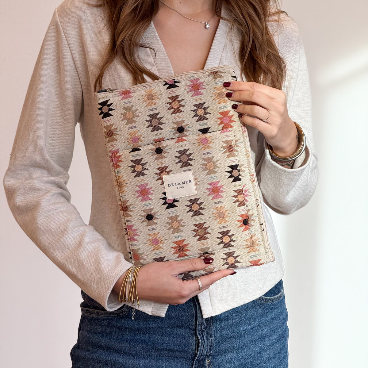 Model holding the DE LA MUR Royal geometric jacquard laptop bag against her body