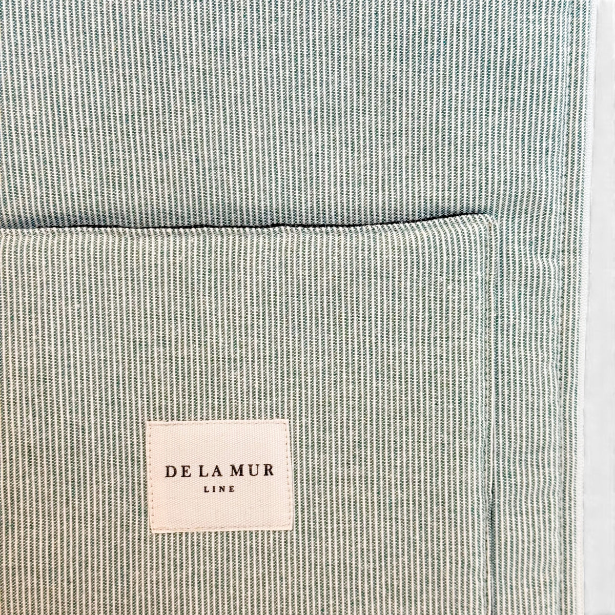 Detail of DE LA MUR Line label on the Teo green and gray laptop bag