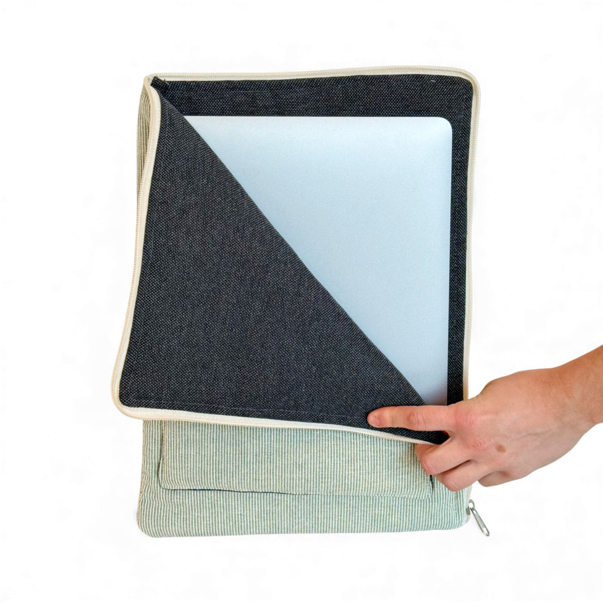 Hand sliding a laptop out of the open DE LA MUR Teo padded laptop sleeve