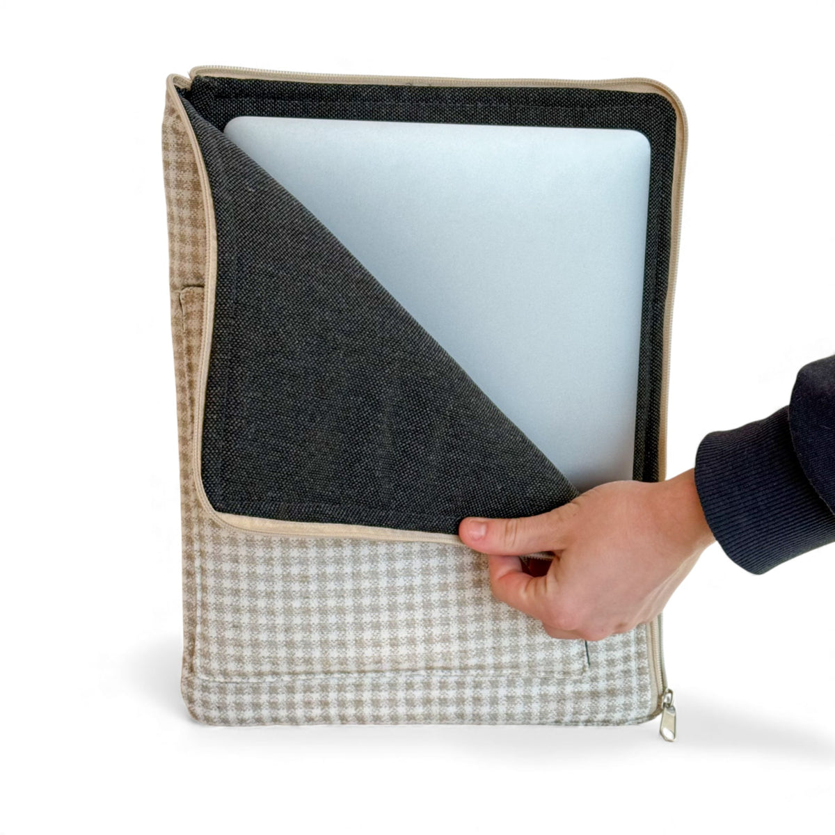 Hand sliding a laptop out of the open DE LA MUR Vison padded laptop sleeve