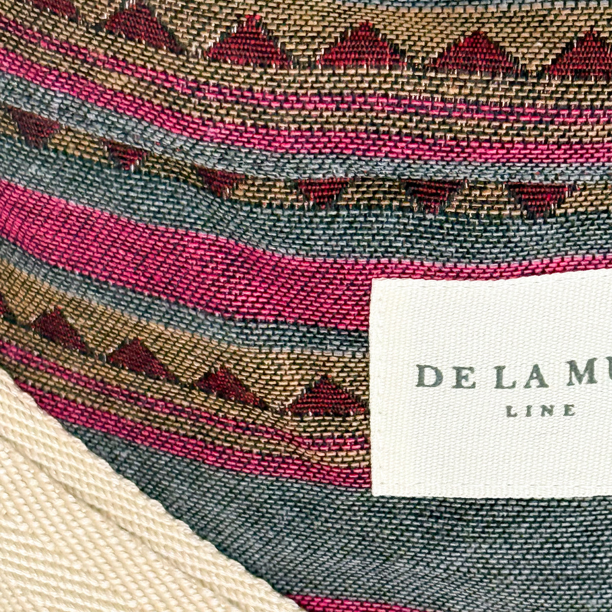 Close-up of the striped jacquard fabric and DE LA MUR Line label on the Aura fanny pack