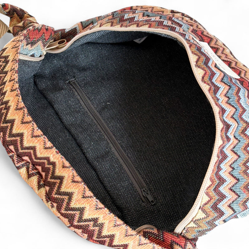 Open DE LA MUR Monte fanny pack showing dark lined interior with zip pocket