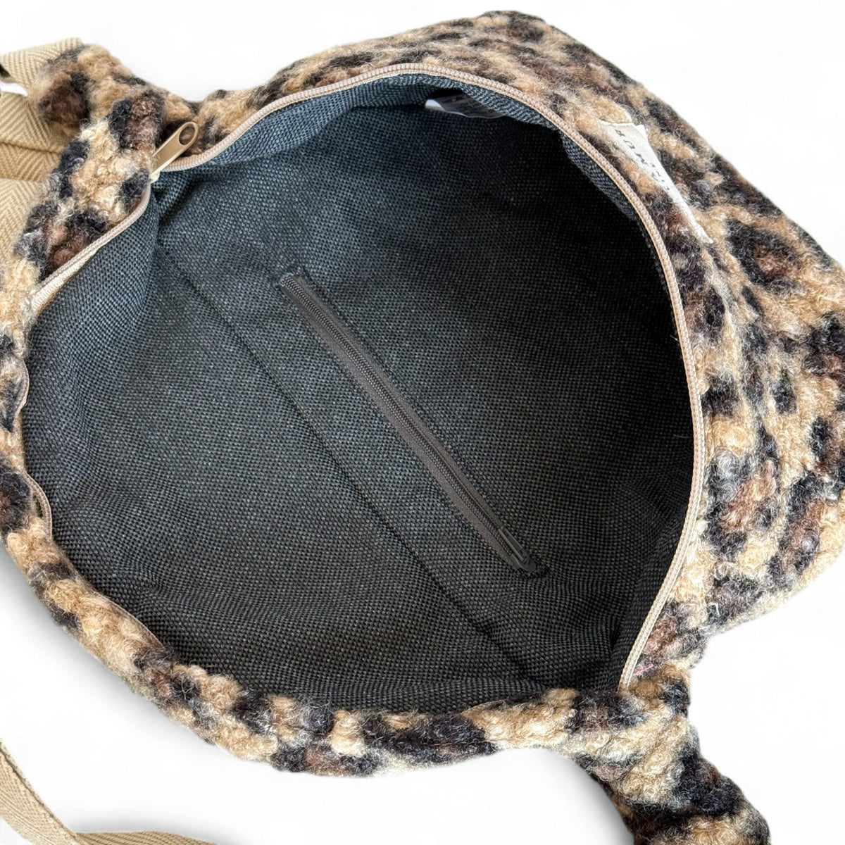 Open DE LA MUR Pardo sherpa fanny pack showing zipped inner pocket and lined interior