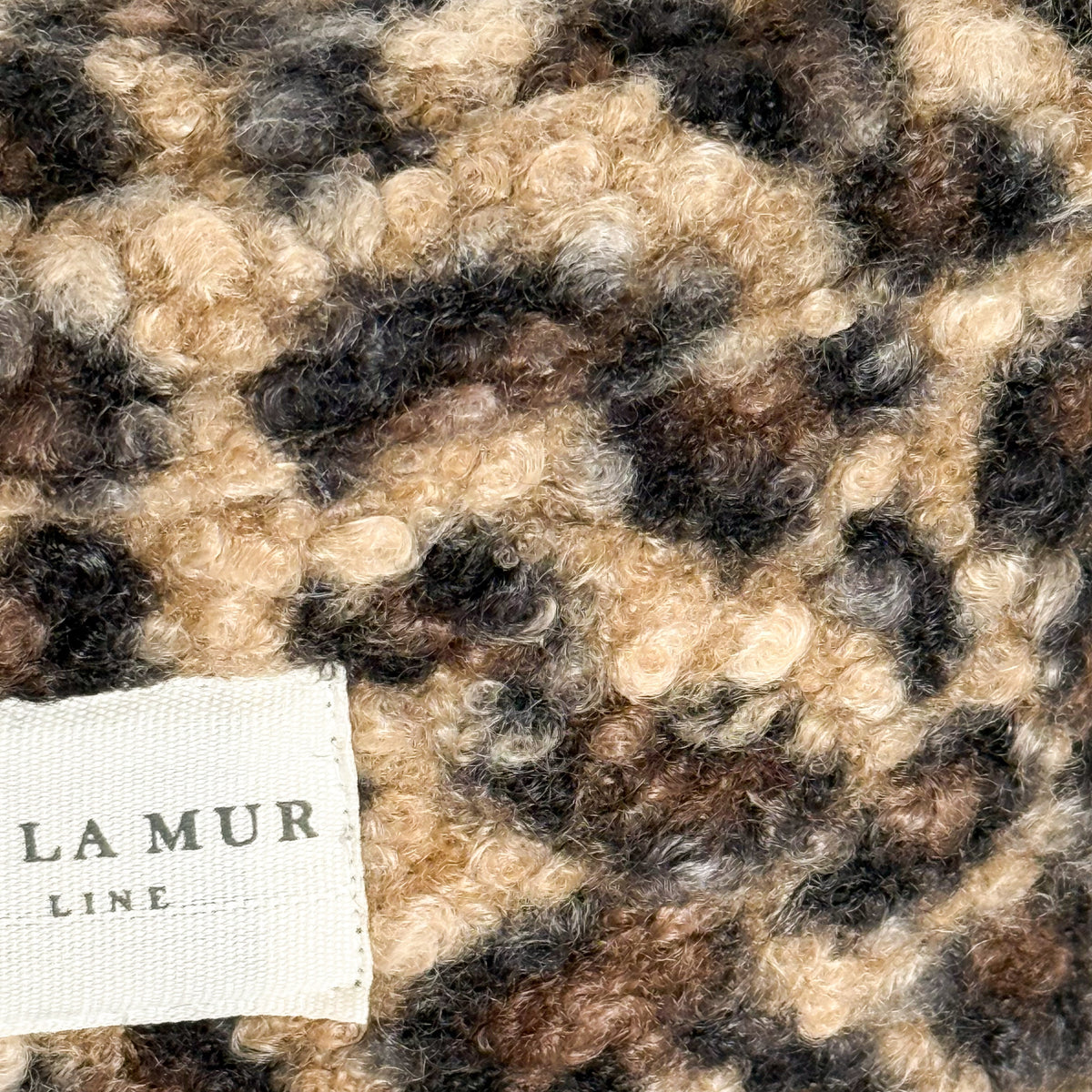 Close-up of the leopard-print sherpa texture and DE LA MUR Line label on the Pardo fanny pack