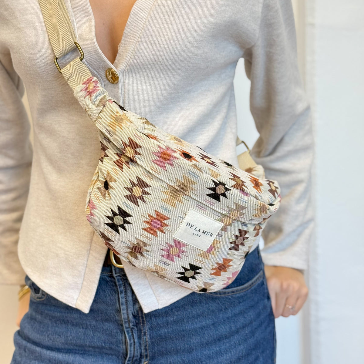 Model wearing the DE LA MUR Royal beige and pink fanny pack at the waist