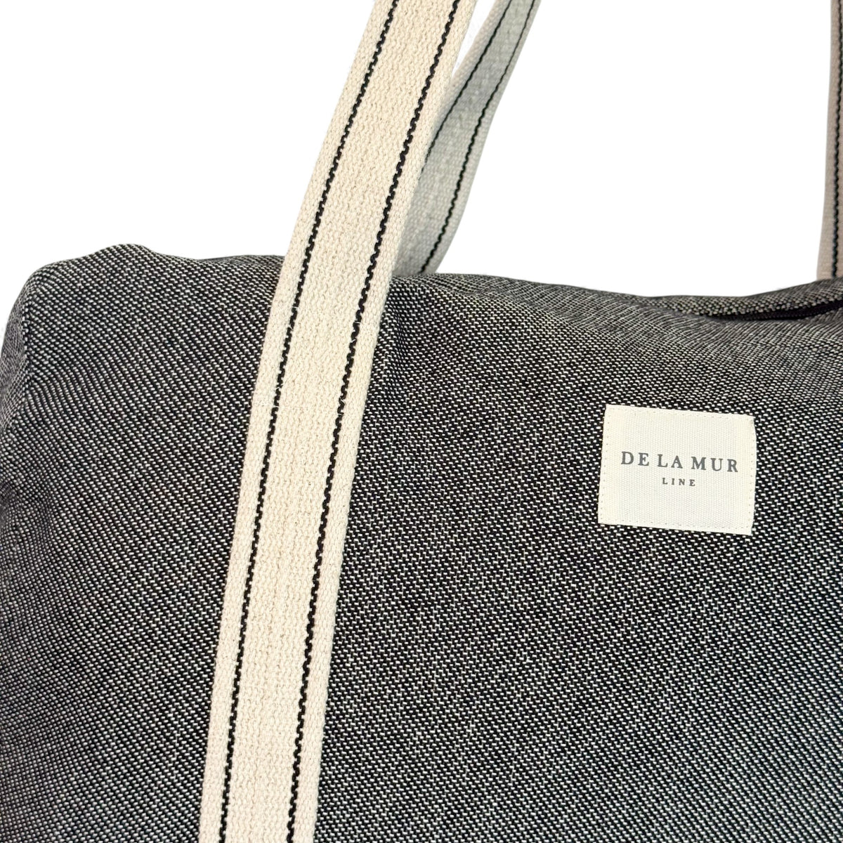 Detail of DE LA MUR Line label and striped straps on the Sinay sports bag