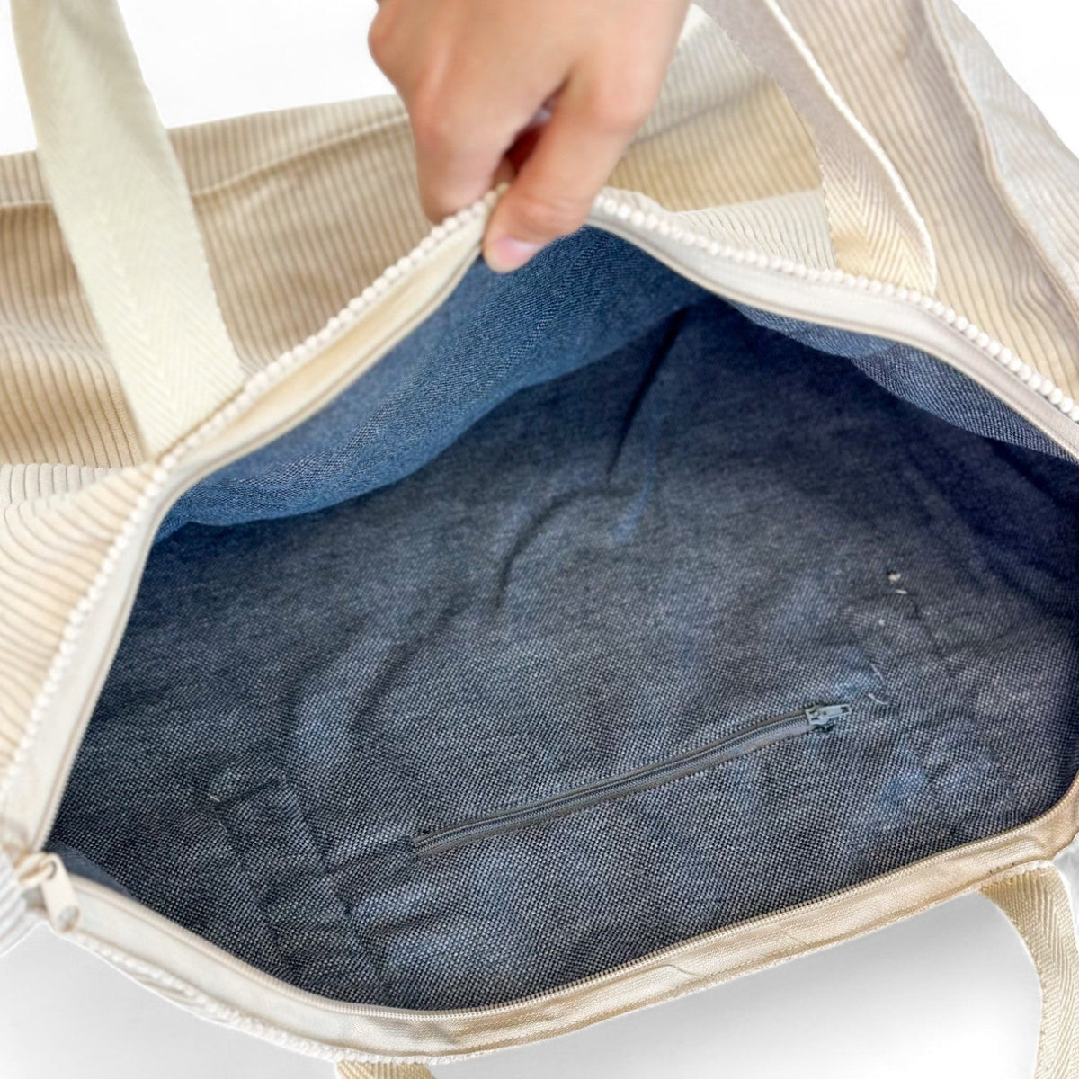 Open DE LA MUR weekender bag showing lined interior and inner zip pocket