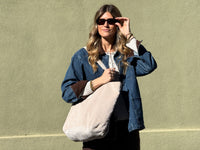 Model carrying the DE LA MUR beige corduroy large tote bag outdoors