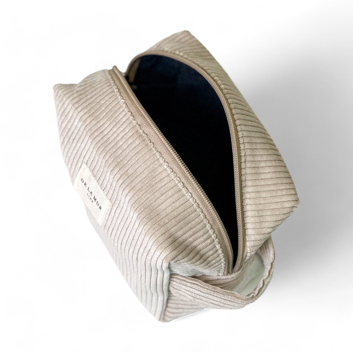 Open DE LA MUR corduroy squared makeup bag showing dark lined interior